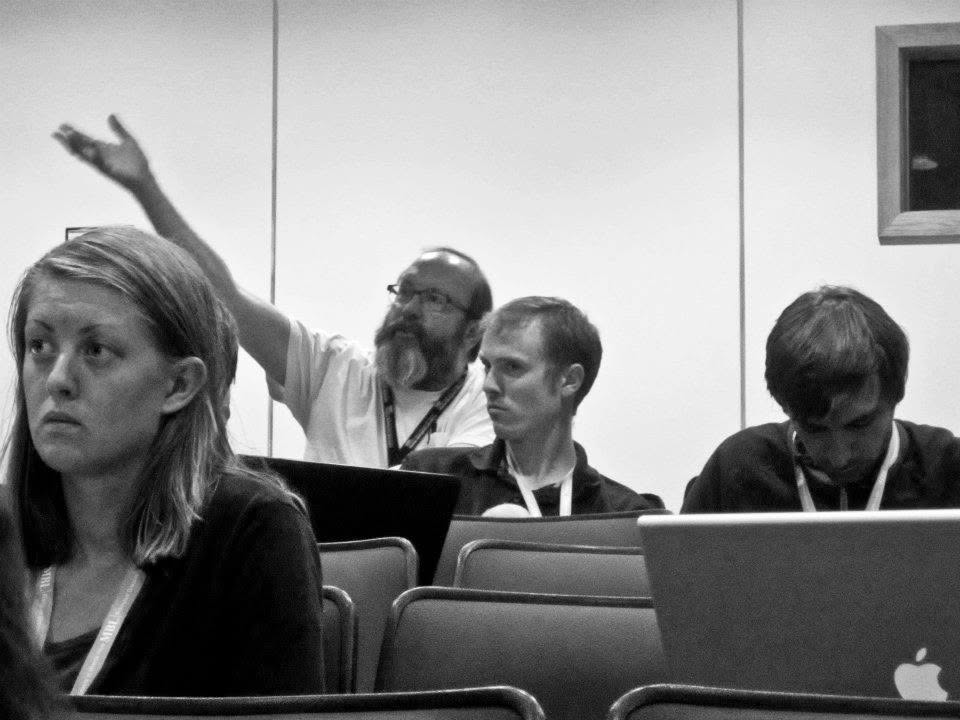 Dustin Mayfield-Jones in a lecture hall at the 2012 MBL Workshop on Molecular Evolution, Woods Hole, with Joseph Felsenstein raising a hand in question behind him and Laurent Frantz seated alongside.